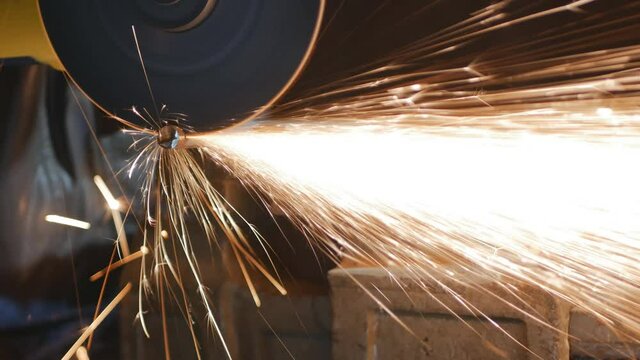 male locksmith cuts metal reinforcement with a steel cutting machine. Sparks fly beautifully forward. Work with grinding and cutting metal structures. 4k