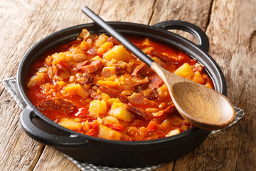Locro stew of squash, beans, corn, potatoes, sausages and meat close-up in a pot on the table. horizontal
