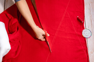 Step by step instructions. Step 3. Master class on creating a red hat of Santa Claus. Cut out the triangular blanks for the hat with sewing scissors.