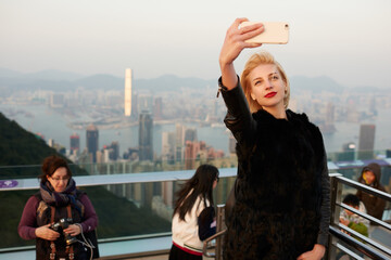 Beautiful woman taking selfie while standing on viewing platform