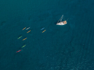 Fototapeta premium Aerial view of canoes sailing near the rugged coastlines and beaches of Lanzarote, Spain, Canaries. Explore the island. Bathers on the beach and in the Atlantic Ocean. Papagayo