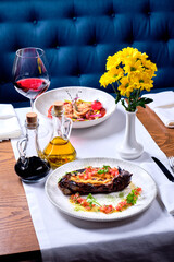 Dish of stuffed zucchini and a meat dish on a table.