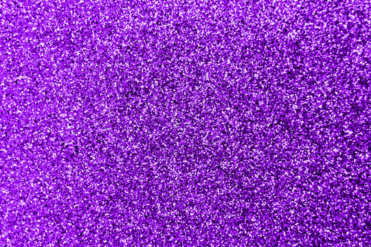 Glitter splash and lens flare on purple shiny trendy background. Sequins. Festive background for your projects. Blurred purple festive bokeh lights. Christmas festive time concept on background.