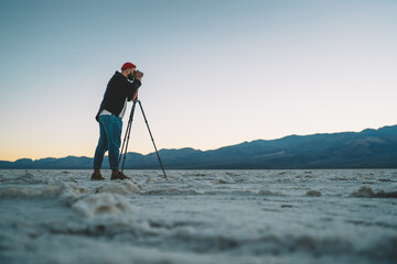 Anonymous man taking pictures of mountains