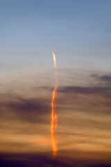 jet airplane flying high against sunset sky background. Passenger plane contrails crossing sky. Cargo aircraft travelling across sky. Aviation vertical wallpaper