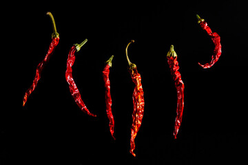 Red hot dried pepper isolated on a black background. Chili peppers, the spicy ingredient, the spice. Beautiful bright vegetable background