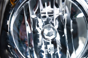 Macro close-up element of reflector of new car headlight headlight. Car background with soft focus