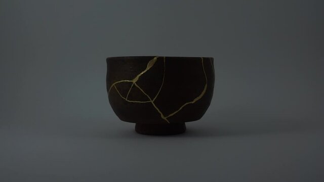Kintsugi antique bien bowl restored. Real gold cracks lighted up. Shining effect. Trauma representation.