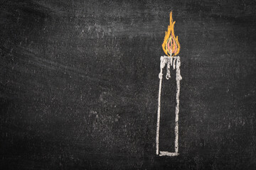 A burning candle drawn on a chalkboard