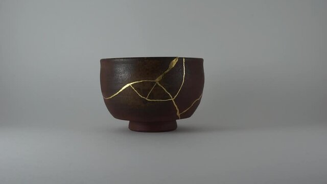 Kintsugi antique bien bowl restored. Real gold cracks lighted up. Shining effect. Trauma representation.