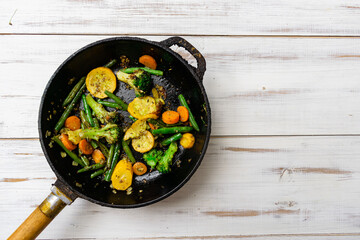 Various fried vegetables in a pan. Mix of carrots, green beans, cauliflower.