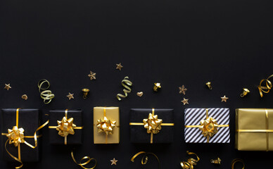 Fototapeta na wymiar Merry christmas,xmas and new year celebration concepts with gift box and ornament in golden color on dark background
