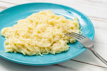 Spaghetti on a plate on a wooden background.