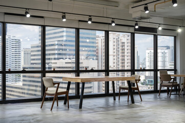 Empty wooden conference table with chairs in coworking space