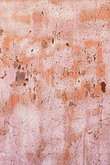 Textured background old faded red paint with white streaks and cracked peeling to rusty metal