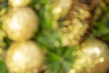 Abstract blurred shiny yellow Christmas balls and cone with barks and pine branches. New year card. Background