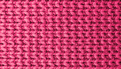 Knitted pink background. Yarn texture. Horizontal knitting