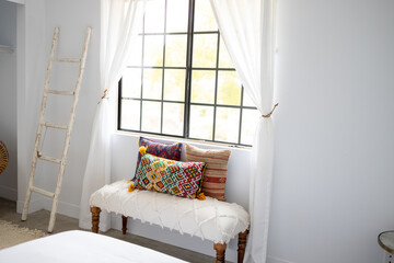 Obraz premium Southwestern Style interior of a bedroom with Decorative Pillows and Bench Under a Window