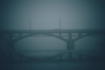 Bridge over a foggy river in the morning