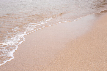 Soft beautiful sea wave on sandy beach. Background texture