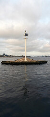 Fototapeta na wymiar White lighthouse on a stone pier in Riga, on the river Daugava