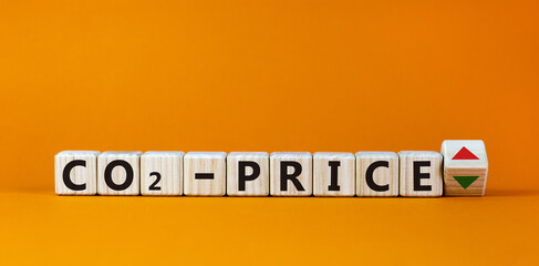 Symbol for an increasing CO2 price. Cubes form the expression 'CO2-price'. Beautiful orange background. Copy space, business concept.