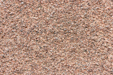 The surface of a rough uneven wall, plastered with fine marble chips.