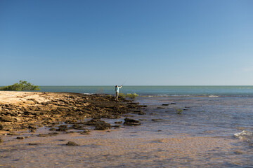 Female at the beach fishing on a sunny day