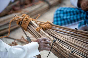 man building a traditional boat on in the UAE, isolated photography a carpenters hand and tools with focus on the hand 