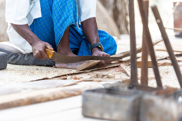 man building a traditional boat on in the UAE, isolated photography a carpenters hand and tools with focus on the hand 