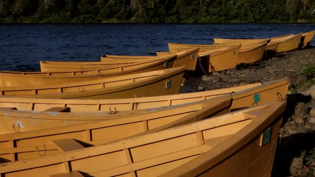 Colourful river boats tied to shore. Fisherman rent these to catch Atlantic salmon. Footage shot at a provincial park in Newfoundland while travelling on vacation. A relaxing and exhilarating activity