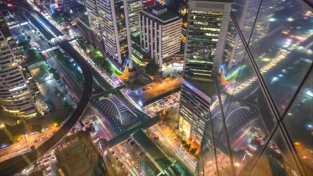Bangkok city, Thailand - October 28, 2020: 4K. Time lapse of aerial view of Sathorn intersection with office buildings, busy streets. Cars traffic on roads and BTS skytrain at night