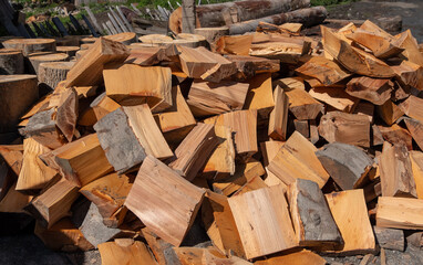 A pile of chopped firewood logs close up.
Pile of dry chopped firewood logs as a background.