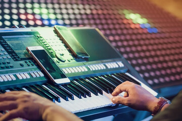 Musician play electronic keyboard synthesizers by using smartphone as guidelines for playing on the...