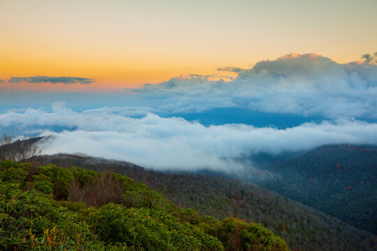 Fog sits over the valley in the Blue Ridge Mountains of North Carolina at sunset.