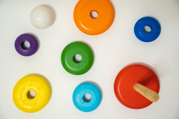 Children's wooden toys. Colorful rings isolated on white background. Pyramid build from colored wooden rings with a clown head on top. Toy for babies and toddlers to joyfully learn mechanical skills