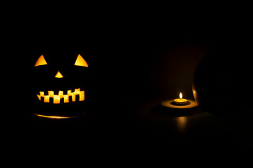 Helloween symbol with scary face behind a candel with fire