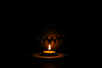 Helloween symbol with scary face behind a candel with fire