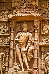 Obraz premium Intricately carved stone statues of Gods and Goddesses on the walls of Modhera Sun Temple in Gujarat State of India. Temple is about 1000 years old and is dedicated to Surya (Sun ) God.