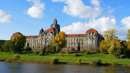 Sächsische Staatskanzlei am Ufer der Elbe in Dresden mit grüner Wiese und blauem Himmel im Herbst