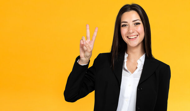 Beautiful young businesswoman portrait, making the victory sign
