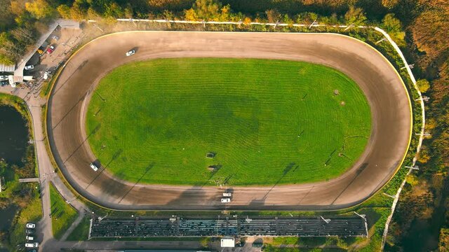 Aerial view on top Races on the racetrack. Cars driving in a circle drifting around corners compete for first place in car racing.