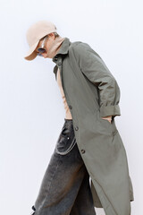  Model in fashion urban street outfit. Trendy cap and military coat. Stylish Fall winter seasons....