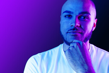 Serious thoughtful black guy portrait in neon light