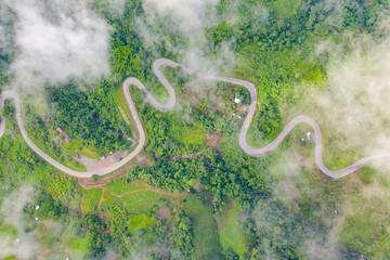 Aerial view of cars driving on curved, zigzag curve road or street on mountain hill with green...