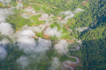 Aerial view of cars driving on curved, zigzag curve road or street on mountain hill with green...