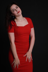 sexy attractive brunette in red skinny dress isolated on black background. studio shoot. emotional actress. . 