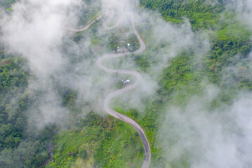 Aerial view of cars driving on curved, zigzag curve road or street on mountain hill with green...