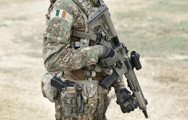 Soldier with assault rifle and flag of Ireland on military uniform. Collage.