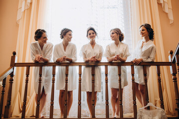 Cheerful, young, attractive witnesses next to the bride. Wedding preparations. Fitting dresses.